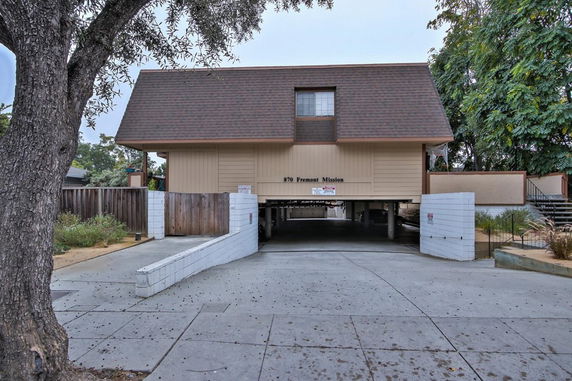 Front view of a building with elevated structure, enclosed parking area underneath.