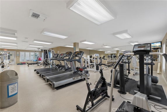 Indoor gym area with various exercise machines and equipment.