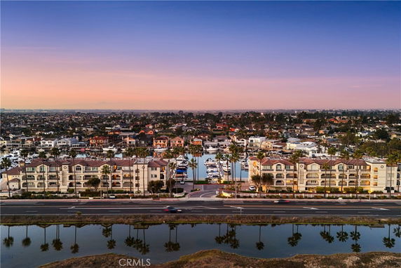 Panoramic view of a waterside residential area with multi-story buildings and boats.