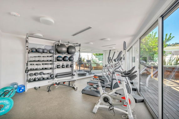 Indoor gym area with exercise equipment and weights.