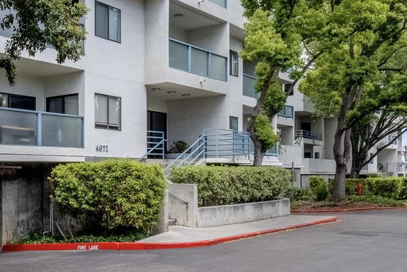 Front view of a multi-story apartment building with balconies and staircases.