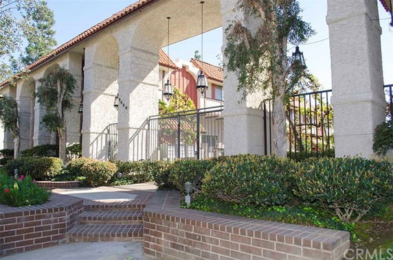 Front view of a gated building with archways and a tiled roof.