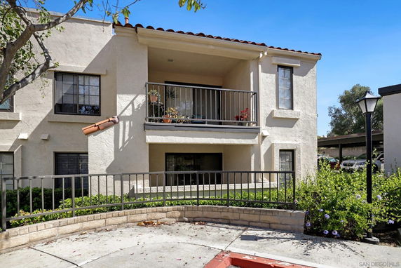 Front view of a two-story house with a balcony and railing.