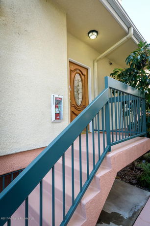 Front view of a building entrance with steps and a decorative door.
