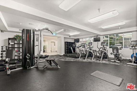 Indoor gym with various exercise equipment and machines.