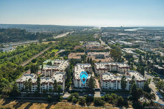 Aerial view of a residential apartment complex with surrounding landscape and infrastructure.