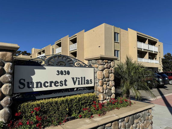 Front view of a multi-story apartment building with balconies.