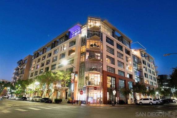 Front view of a multi-story residential building with large windows and balconies.