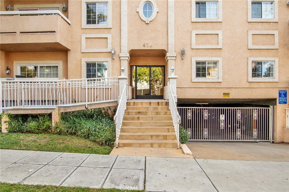 Front view of a multi-story building with a staircase leading to the entrance.