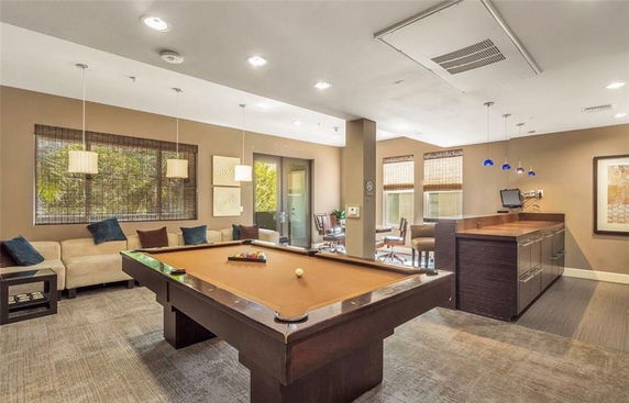 Interior with a billiards table, sofas, and bar area.