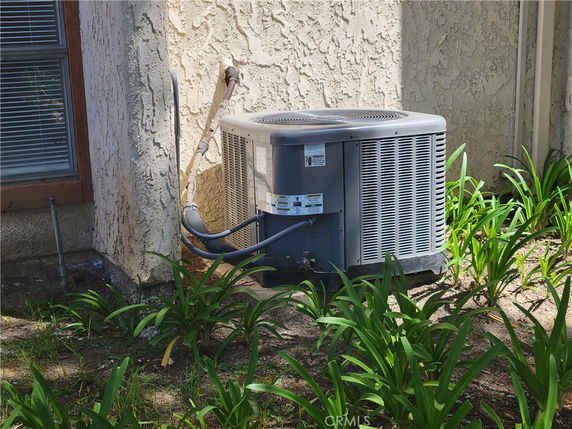 Exterior view of a building wall with an air conditioning unit installed.