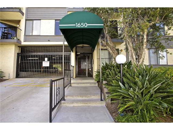 Front entrance of a multi-story residential building with a green awning.
