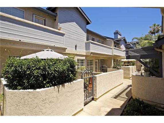 Front view of a multi-story residential building with balconies and a gated entrance.
