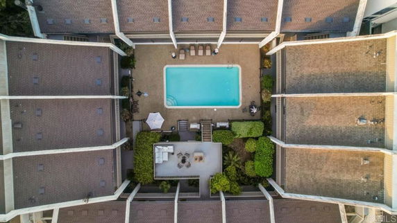 Aerial view of a central swimming pool surrounded by buildings with a courtyard layout.