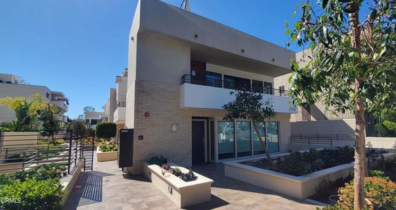 Front view of a modern two-story house with large windows and a balcony.