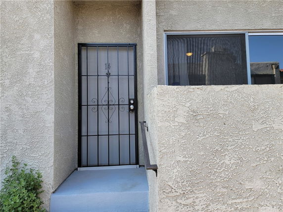 Entry view of a building with a metal security door and adjacent window.