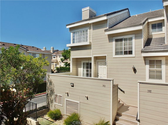 Front view of a two-story townhouse with beige siding and white trim.
