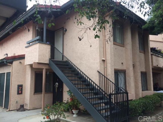 Front view of a two-story house with an external staircase.