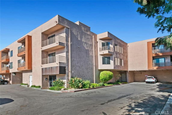 Front view of a multi-story apartment building with balconies.