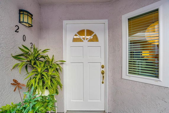 Front view of a house entrance with a white door and window.