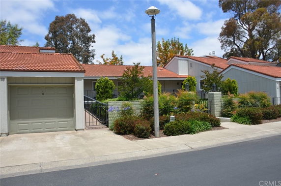 Front view of a single-story house with a garage and tile roof.