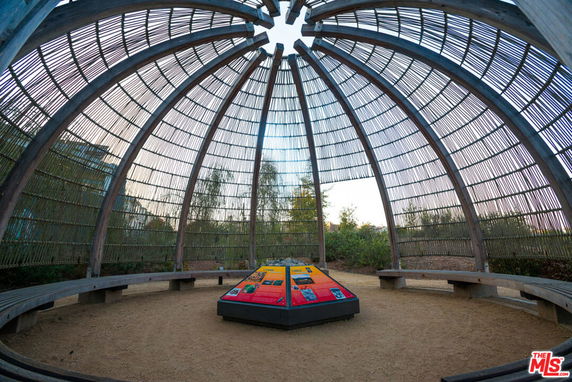 Dome-shaped structure with open sides and wooden benches around the perimeter.
