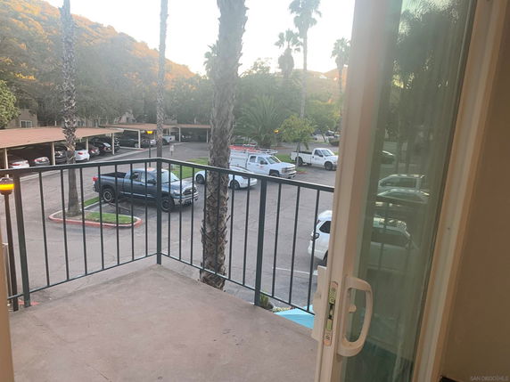 View of a parking area with multiple vehicles and covered parking spaces.