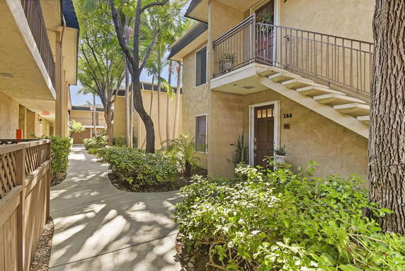 Pathway and exterior view of an apartment complex with stairs and garden.