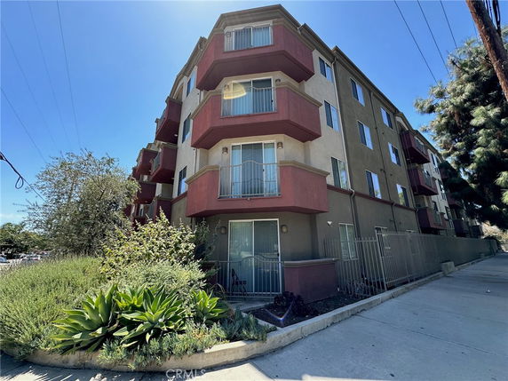 Front view of a multi-story apartment building with balconies.