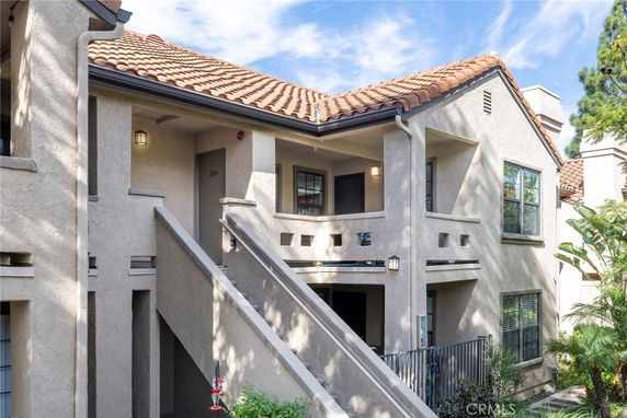 Front view of a multi-story residential building with a staircase leading to the upper level.