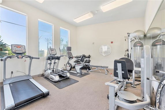 Room with gym equipment including treadmills and exercise machines.