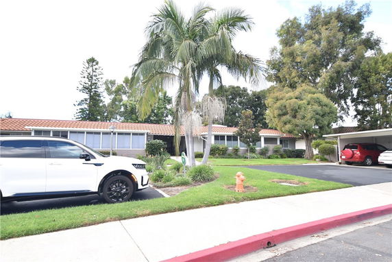 Front view of a single-story house with tiled roof and covered parking area.