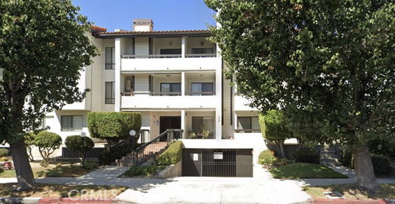 Front view of a multi-story apartment building with balconies.