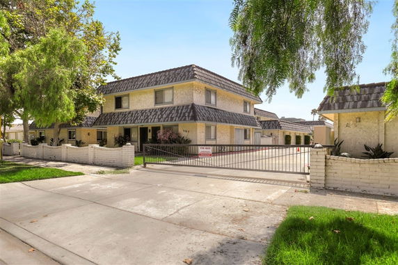 Front view of a two-story residential building with gated entrance.
