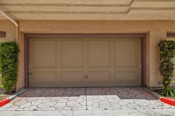 A closed garage door with a paved driveway area.