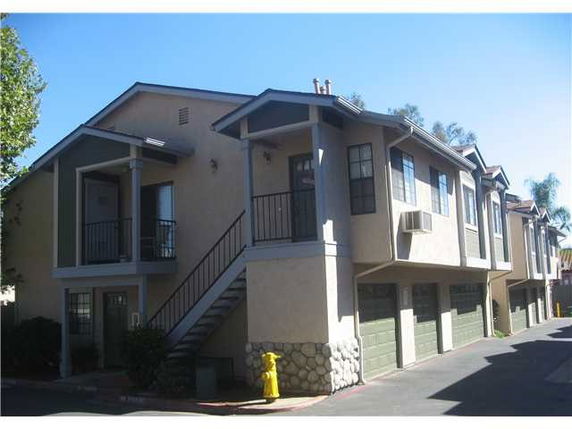 Front view of a two-story apartment building with garages on the ground floor.