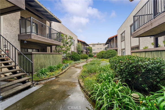 Outdoor view of apartment buildings with balconies and a garden path.