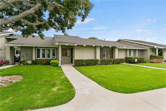 Front view of a single-story house with a well-maintained lawn and walkway.