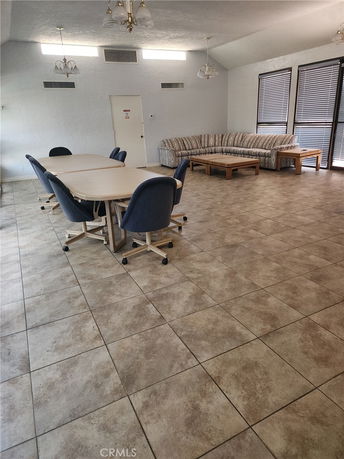 Interior room with a table, chairs, and a sofa indicating a common area for recreation.