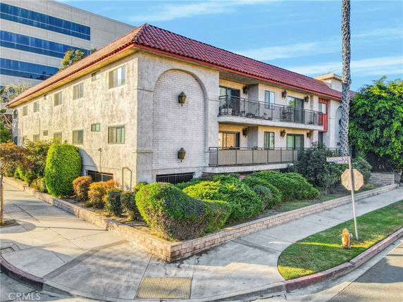 Front view of a two-story building with a red tile roof and balconies.