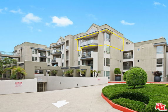 Front view of a multi-story apartment building with balconies.