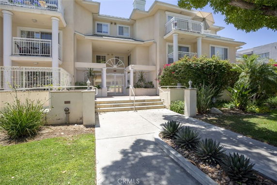 Front view of a multi-story house with balconies and columns.