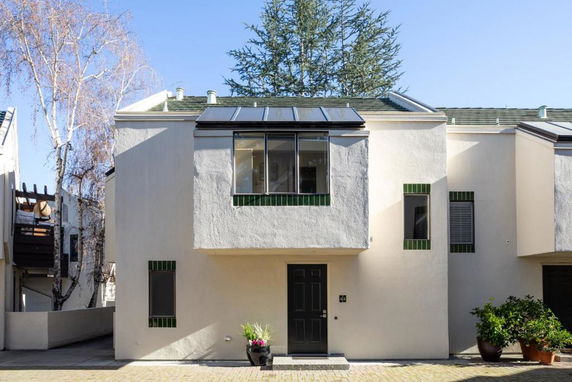 Front view of a two-story house with solar panels.