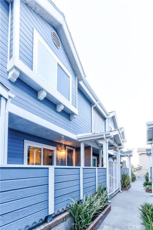 Front view of a two-story blue house with white trim.