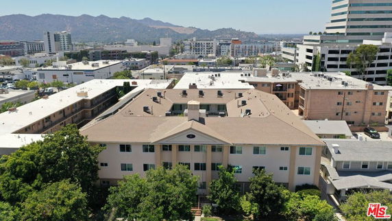 Front view of a multi-story apartment building with a gabled roof.