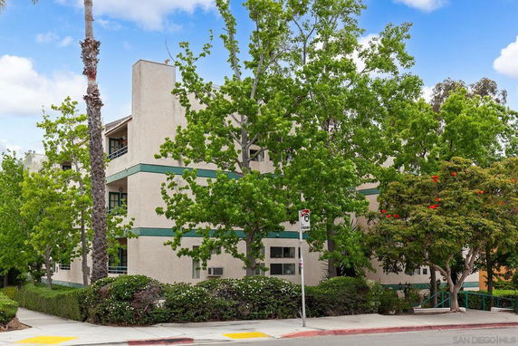 Front view of a multi-story residential building with greenery.