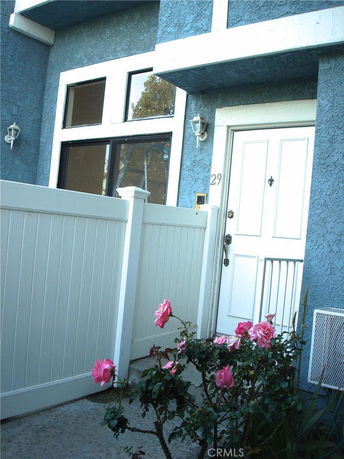 Front view of a house with blue exterior walls and a white door.