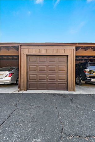 Outdoor covered parking area with cars.