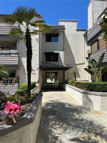 Front view of a multi-story building with a walkway leading to the entrance.