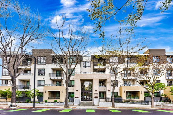 Front view of a multi-story residential building with balconies and large windows.